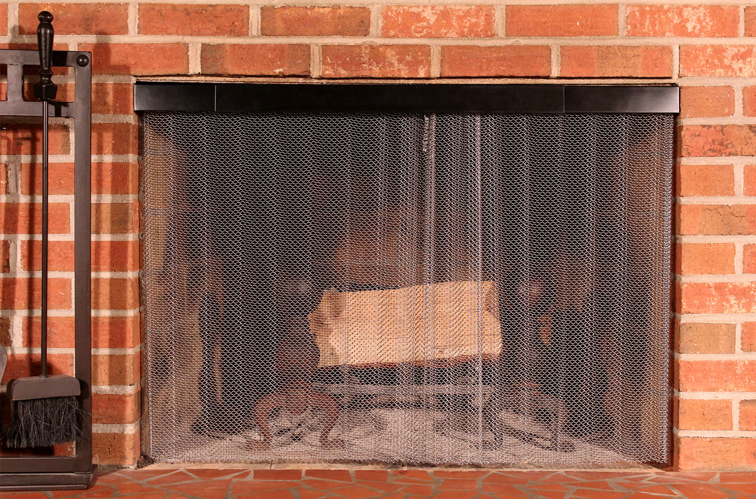 Condar stainless steel mesh fireplace screen and black rod and valance kit installed in brick fireplace