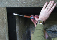Slide both valance extensions back to meet either side of the outer wall. Then secure extensions to inner wall of your firebox with tapcon screws.